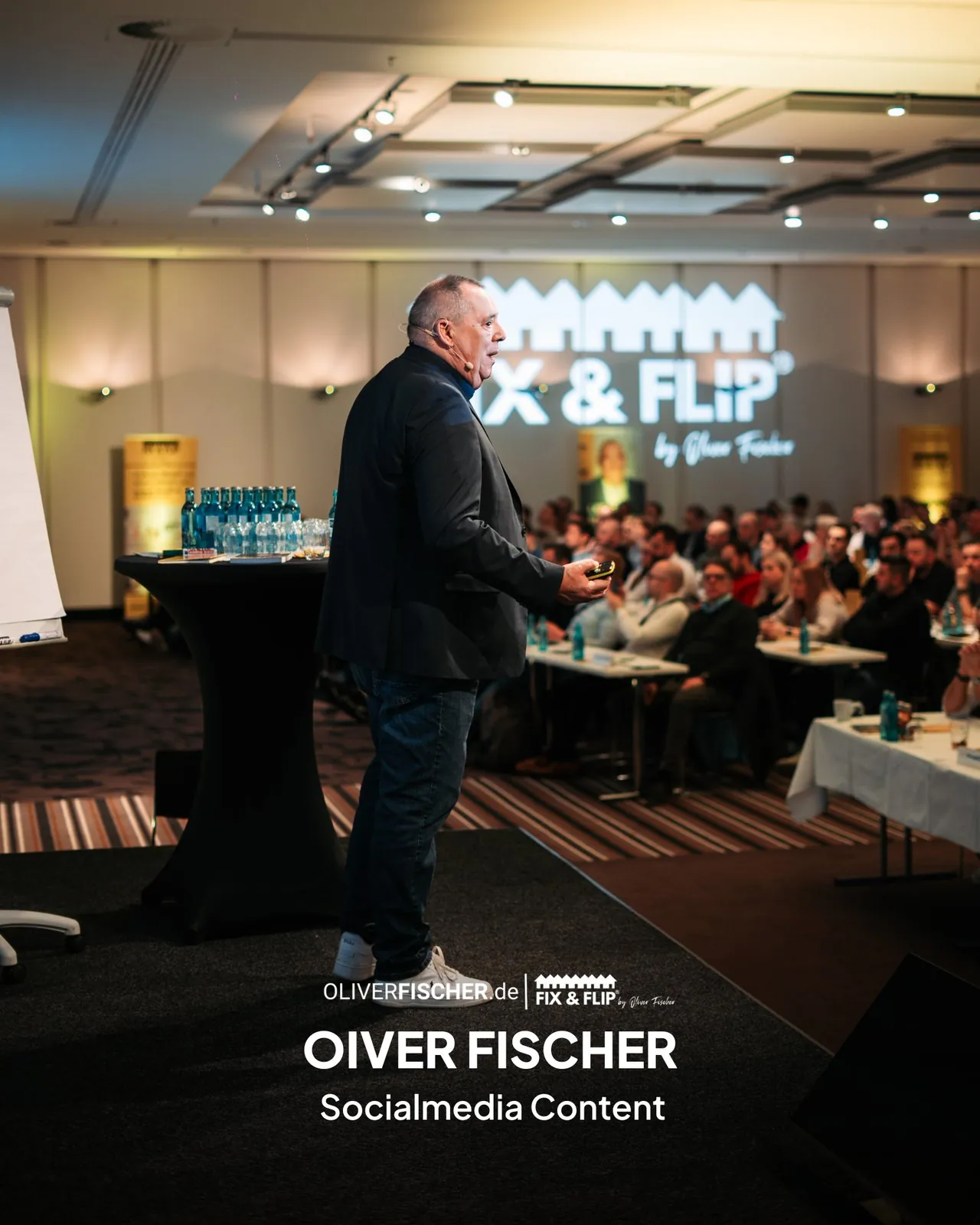 Oliver Fischer von FIX & FLIP bei einem Vortrag auf der Bühne, Kundenbeispiel für Social Media Content von Amro Media.