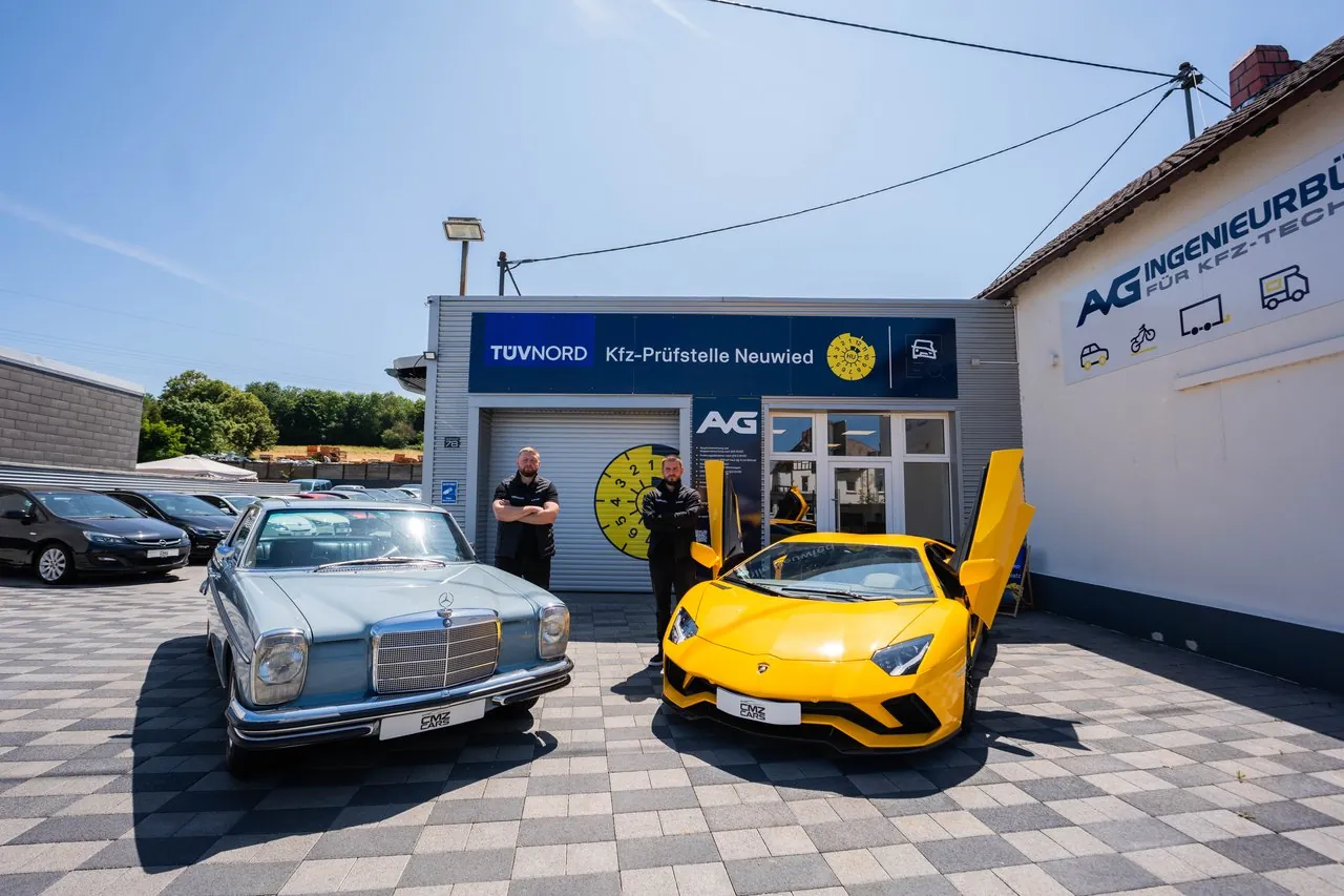Gebäude des AVG Ingenieurbüros mit Oldtimer und Sportwagen davor