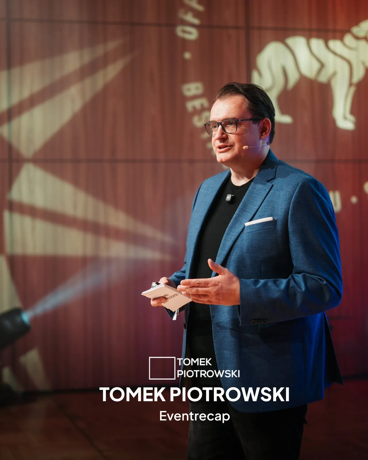 Tomek Piotrowski auf der Bühne, Kundenbeispiel für Eventrecap und B2B-Videoproduktion von Amro Media.