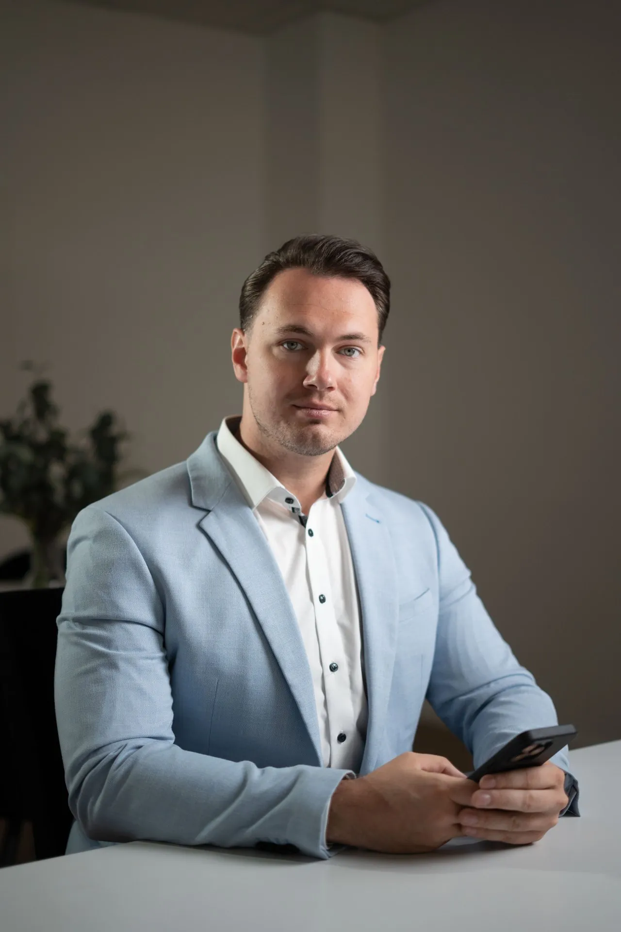 Julien Feller am Schreibtisch mit Smartphone