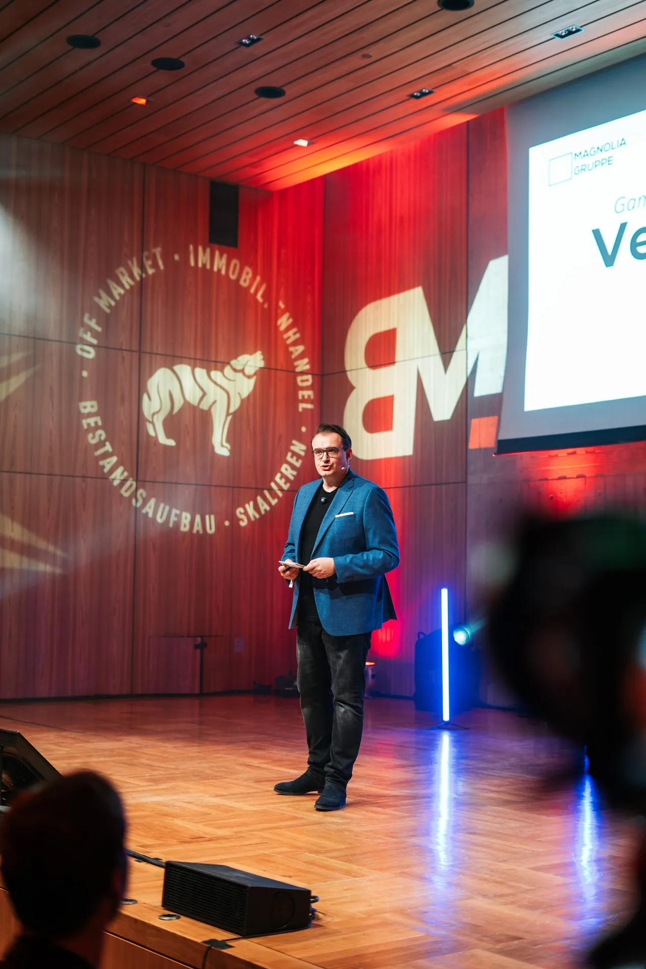 Tomek Piotrowski bei seinem Vortrag, im Hintergrund die Präsentation
