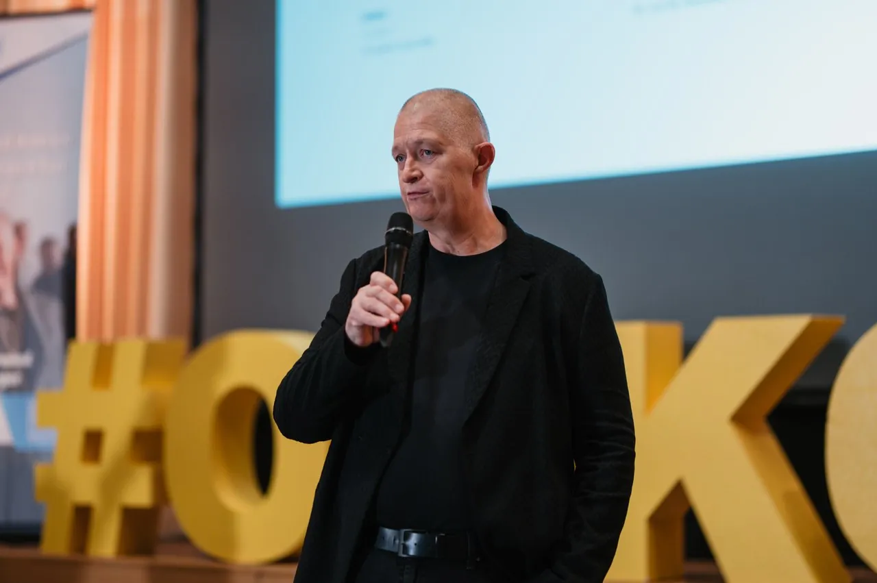 Joschi Haunsperger spricht mit Mikrofon auf der OMKO-Bühne