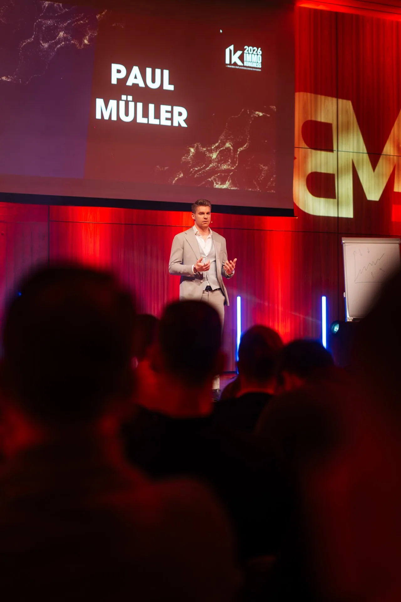 Paul Müller spricht auf der Bühne vor großem Publikum