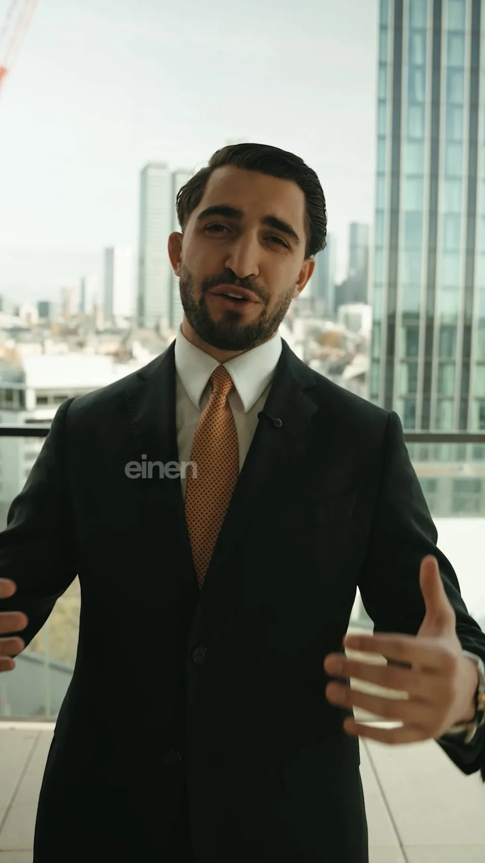 Makler von Kalyon Immobilien im Anzug vor einer Hochhaus-Skyline